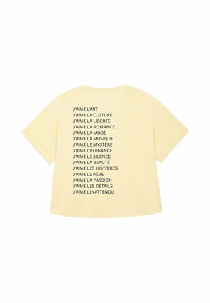 T-shirt jaune arborant des phrases françaises imprimées exprimant l'amour de l'art, de la culture, de la liberté, de la musique et de divers autres thèmes, affichées verticalement.