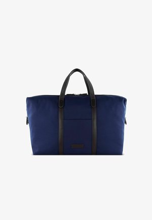 Sac de sport bleu marine fabriqué en tissu durable, équipé de poignées en cuir noir, d'une poche avant et d'une fermeture zippée.