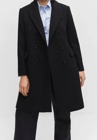 Sort uldblandings dobbeltradet frakke med klapkrave, seks forreste knapper og sidelommer. Glat, struktureret silhuet.