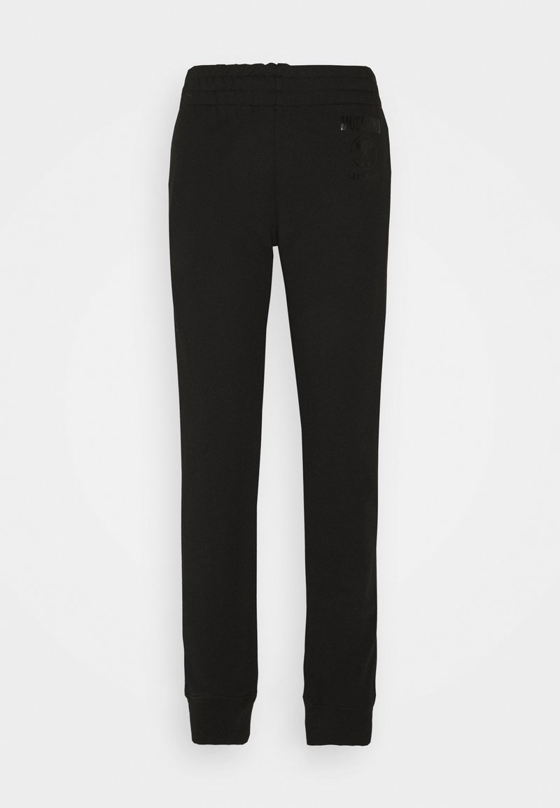 Svarta sweatpants med elastisk midja, avsmalnande ben och en diskret logodetalj på sidan. Tillverkade av mjukt bomullstyg.