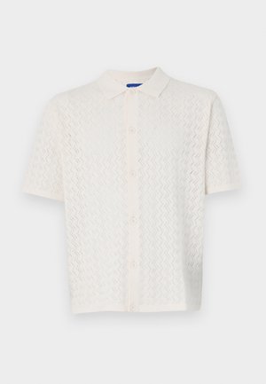 Polo a maniche corte in bianco sporco, caratterizzato da un motivo testurizzato, chiusura con bottoni e design del colletto classico.