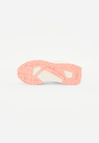 Semelle de chaussure de sport avec grip texturé en couleurs rose et crème. Dispose d'une bande de roulement avec motif et détail de logo au talon.