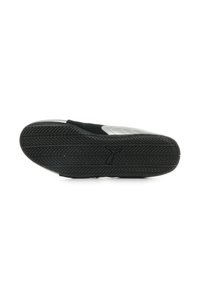 Suela de zapato de goma negra con un patrón de relieve texturizado y un upper gris. Presenta una superficie lisa y un logotipo estampado en la parte inferior.