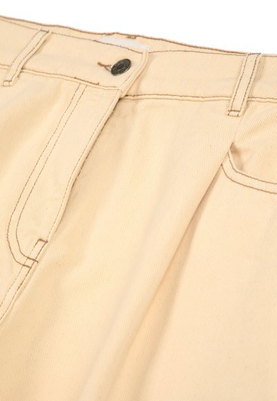 Pantalons en coton beige avec une fermeture à bouton, présentant une texture en côtes diagonales, des poches avant et des coutures contrastées le long des seams.