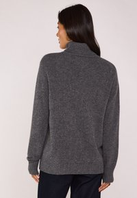 Maglione grigio con collo alto, realizzato in materiale morbido. Caratterizzato da maniche lunghe e polsini e orlo a costine, offre una vestibilità comoda.