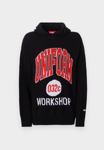 Hoodie en tricot noir avec un texte rouge et blanc en gras : "UNIFORM 032c WORKSHOP." Design simple avec des manches et un ourlet côtelés.