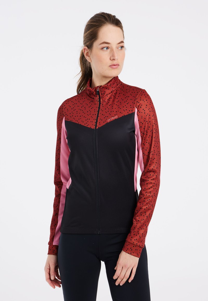 Röd och svart atletisk jacka med hög krage, dragkedjestängning och prickmönster på de röda ärmarna. Har rosa sidpaneler och stretchigt material.