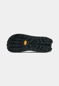 Czarna gumowa podeszwa buta z głębokim wzorem bieżnika i logo Vibram, posiadająca trójkątne i prostokątne wypustki na podeszwie zapewniające przyczepność.