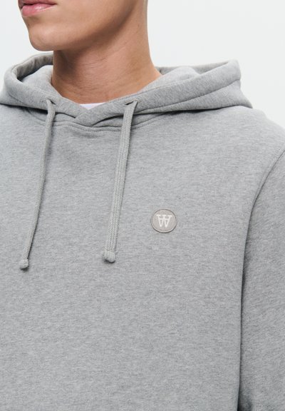 Gray hoodie with a drawstring hood, made of soft fabric. Features a round, embroidered logo on the chest in a lighter shade.