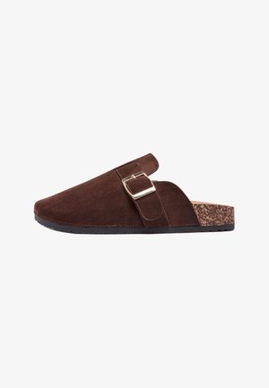 Sabot marron en daim avec sangle réglable à boucle et semelle en liège, conçu pour un usage décontracté.
