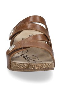 Sandales en cuir marron avec deux larges lanières et des accents en argent en forme de fleurs. Semelle en liège et semelle intérieure à imprimé floral. Design ouvert à l'avant.