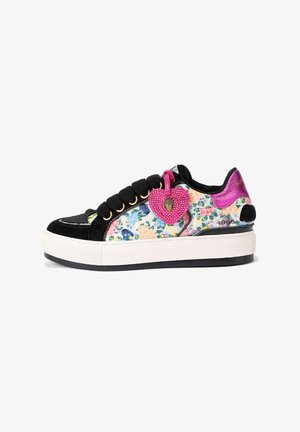 Sneaker con motivo floreale con punta e dettagli in suede nero, suola platform bianca e un ciondolo a forma di cuore rosa attaccato ai lacci.