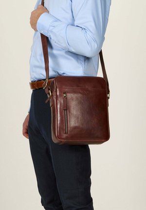 Borsa messenger in pelle marrone con tasca frontale con cerniera e strap regolabile, caratterizzata da una texture liscia e forma quadrata.