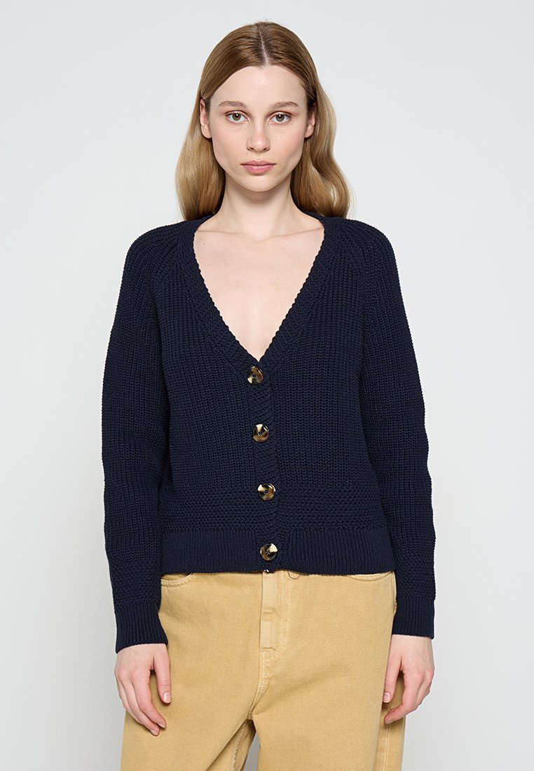 Marineblauer Strickcardigan mit tiefem V-Ausschnitt, sieben großen runden Knöpfen, geripptem Saum und langen Ärmeln. Der Stoff hat ein strukturiertes Muster.