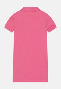 Rochie polo roz din bumbac texturat, cu guler și mâneci scurte. Designul este solid, fără modele sau accente.