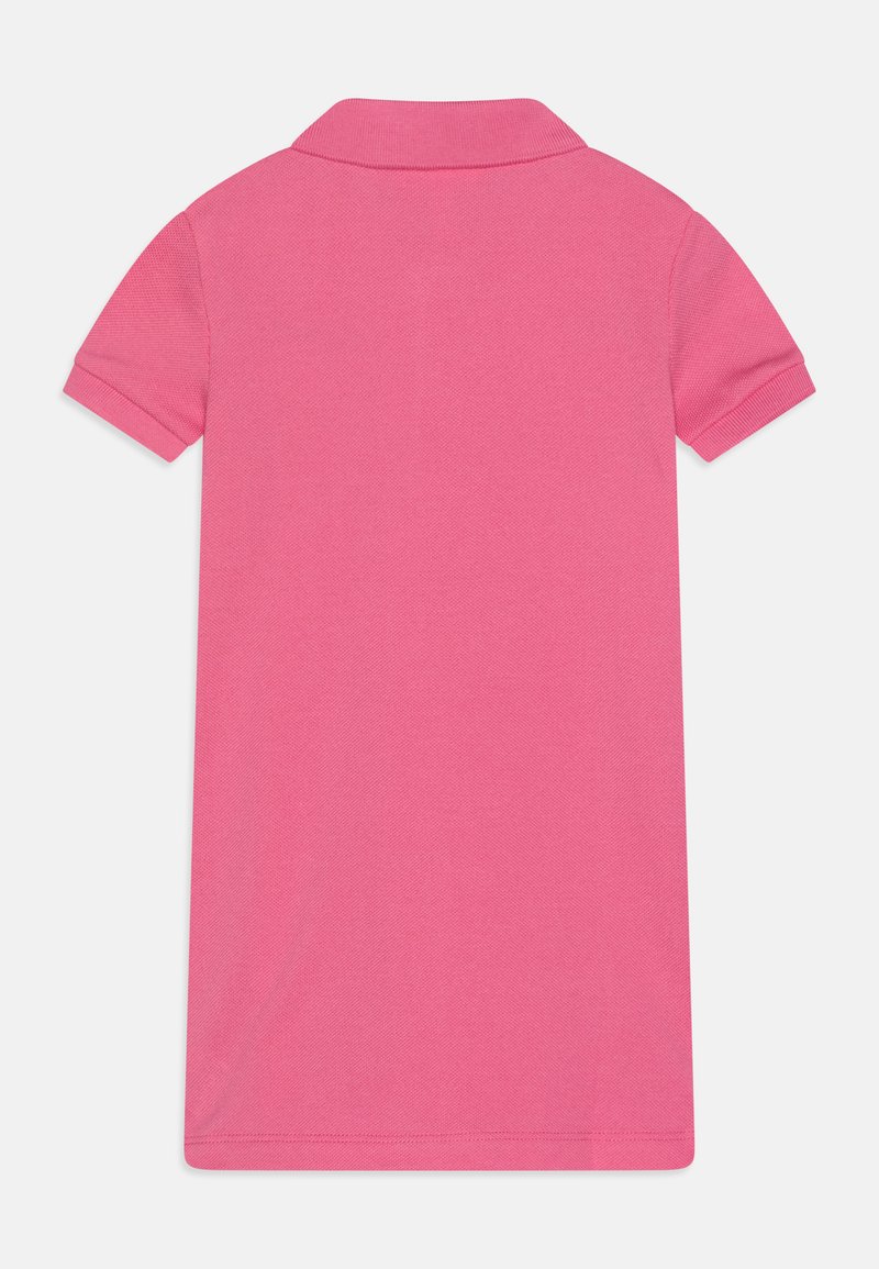 Robe polo rose en coton texturé, avec un col et des manches courtes. Le design est uni, sans motifs ni accents.