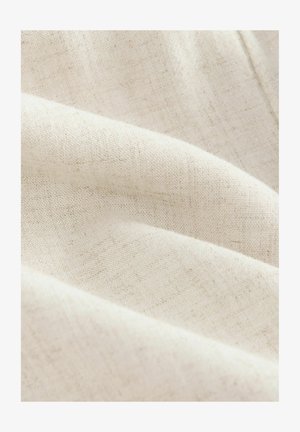 Linne i en mjuk, off-white färg med en slät, något texturerad yta och subtila variationer i tråden.