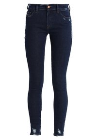 Vaqueros skinnies azul oscuro con detalles desgastados en el frente y en el dobladillo, hechos de material de mezclilla, con cierre de botón y cremallera.