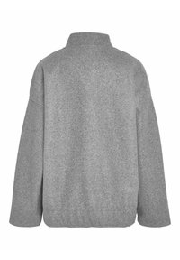 Giacca grigia in misto lana con colletto alto, vestibilità ampia e spalle cadenti. La texture sembra morbida e accogliente, con un design minimale.