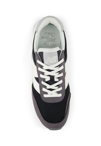 Schwarze und weiße Sneaker aus Mesh- und Wildledermaterialien. Mit weißen Schnürsenkeln, einer strukturierten grauen Ferse und einem geprägten Logo auf der Zunge.