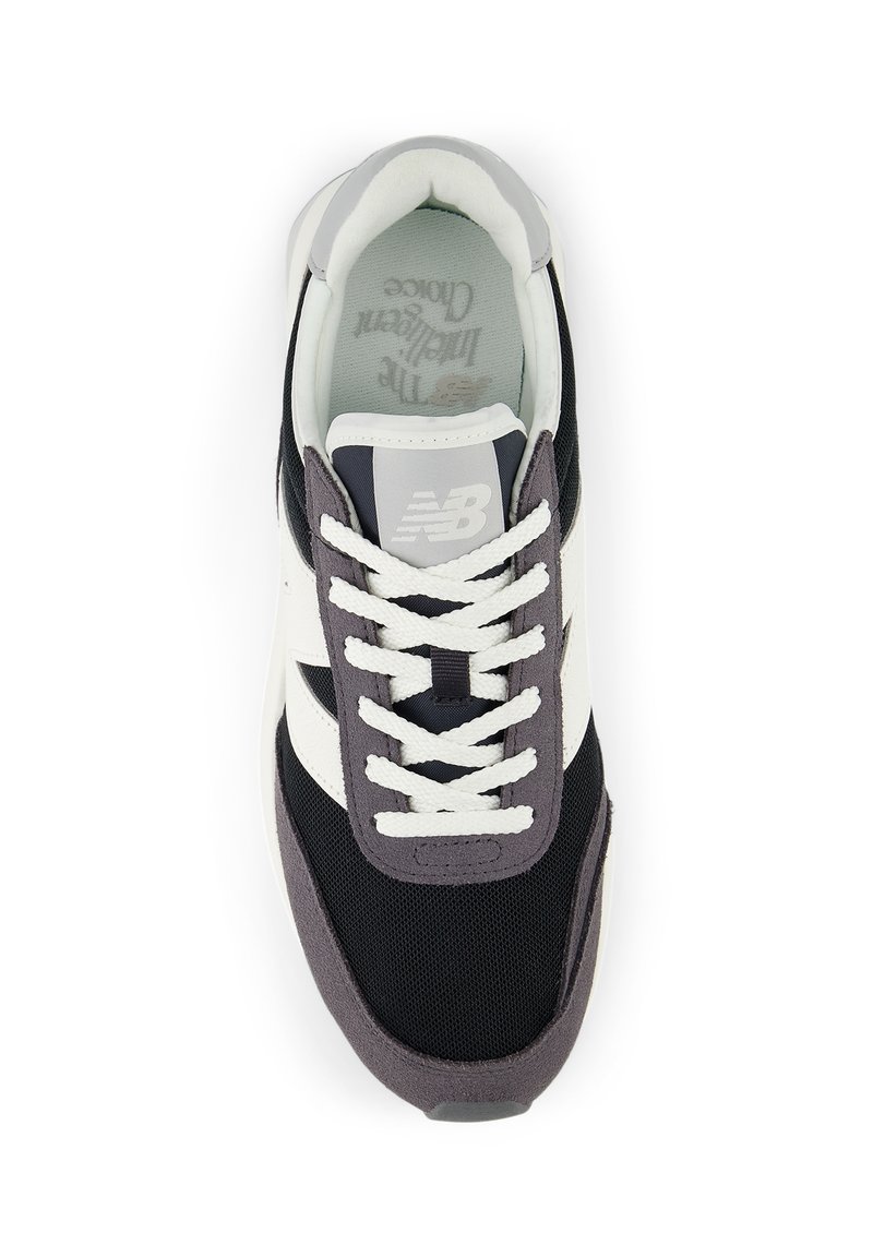 Sneaker nero e bianco realizzata con materiali in rete e suede. Presenta lacci bianchi, un tallone grigio testurizzato e un logo impresso sulla linguetta.