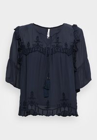 Blusa blu navy con motivi floreali ricamati, maniche a volant e scollatura a V. Presenta un laccio con nappine sul davanti. Tessuto leggero.