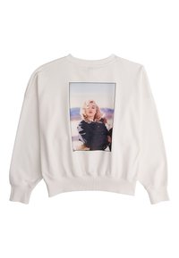 Sweat-shirt blanc avec une photo en couleur d'une femme aux cheveux blonds portant une veste sombre, sur un fond extérieur.
