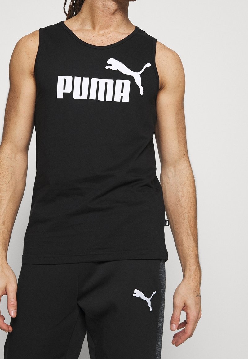 Débardeur sportif noir sans manches avec logo "Puma" blanc et motif de chat bondissant, associé à un pantalon noir avec détail du logo.