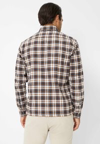 Camicia da uomo a maniche lunghe con motivo a quadri marrone, crema e blu. Presenta polsini con bottoni e un colletto ribassato, realizzata in tessuto testurizzato.