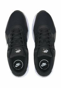 Les baskets Nike noires présentent une tige en mesh, des lacets plats et une semelle blanche. Logo imprimé sur la languette et la semelle intérieure, avec des accents texturés subtils.