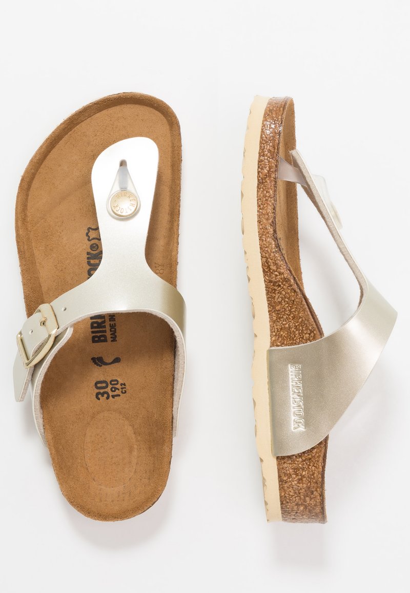 Silver Birkenstock-sandaler med korkfotbädd, en slät läderrem med en metallspänne och en strukturerad gummisula.