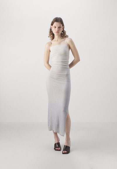 Bodycon, ärmlös klänning i en gradient av ljusgrått med en sidoklyvning. Slät textur och lätt tyg. Matchas med svarta klackar med öppen t�å.