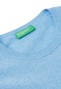 Hellblauer Strickpullover mit Rundhalsausschnitt und einem grünen Etikett mit der Aufschrift "UNITED COLORS OF BENETTON", das in den Ausschnitt genäht ist.