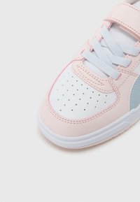 Αθλητικά παπούτσια σε ροζ και  λευκό συνθετικό δέρμα με διάτρητη μύτη, γκρι λεπτομέρεια και λευκά κορδόνια· επίπεδη σόλα από καουτσούκ. Κλείσιμο με λουράκι βέλκρο.