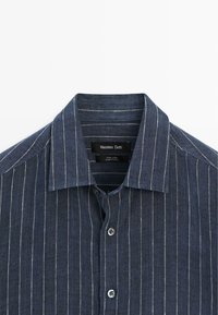 Marineblauw linnen overhemd met witte verticale strepen, klassieke kraag en knoopsluiting aan de voorkant van Massimo Dutti.