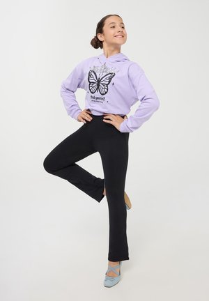 Felpa con cappuccio viola con grafica di farfalla e testo, abbinata a leggings neri e scarpe azzurro chiaro con dettaglio a fiocco.