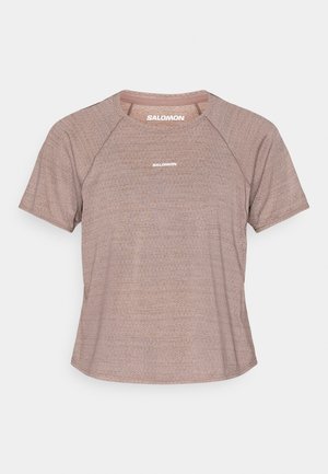 Tricou sport cu mâneci scurte, roz deschis, cu model în nuanțe și mâneci raglan, decolteu rotund. Prezintă un mic logo alb "SALOMON" pe partea din față.