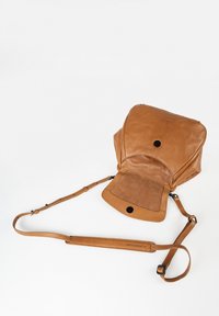 Zaino in pelle marrone con finitura liscia, chiusura a pattina, tracolla regolabile e tasca foderata in camoscio sul fronte.