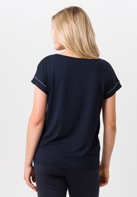 Navyblauwe T-shirt met korte mouwen, zachte stof, ontspannen pasvorm, ronde halslijn, opgerolde manchetten, zichtbare stiksels langs de mouwen en de zoom.