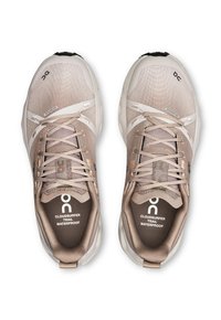 Helle beige Trailrunningschuhe mit einem wasserdichten Obermaterial, strukturiertem Mesh und reflektierenden Akzenten; Schnürdesign und gepolsterte Einlegesohlen.