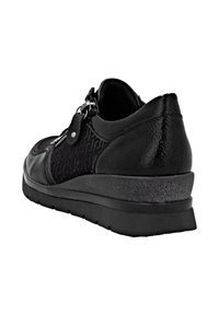 Sneaker noir avec un upper texturé, des accents en cuir lisse, une fermeture éclair et une semelle extérieure épaisse de couleur noire avec une finition légèrement pailletée.