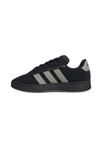 Schwarze Low-Top-Sneaker mit grauen Streifen, schwarzen Schnürsenkeln und einer dicken schwarzen Sohle, seitliche Ansicht isoliert auf weißem Hintergrund.