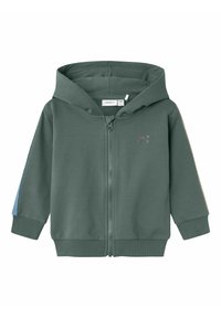 Sudadera verde con cremallera fabricada en un tejido suave, que cuenta con un bolsillo canguro, puños de canalé y detalles en azul y beige en las mangas.