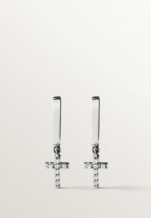 Par de pendientes de plata con pequeños colgantes en forma de cruz incrustados con diamantes, colgando de ganchos rectangulares delgados sobre un fondo blanco liso.