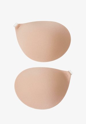 Coussinets en silicone de couleur pêche douce, de forme ovale avec une texture lisse, dotés d'un adhésif transparent en haut pour une application sécurisée.