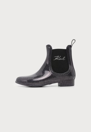 Glanzende zwarte enkellaars voor regen met elastisch zijpaneel en trekkoordje, met "Karl"-branding aan de buitenkant.