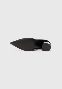 Sorte spidse hæle med en blank patentfinish og en gummisåle med en lille blokhæl for stabilitet. Enkel design, ingen mønstre.