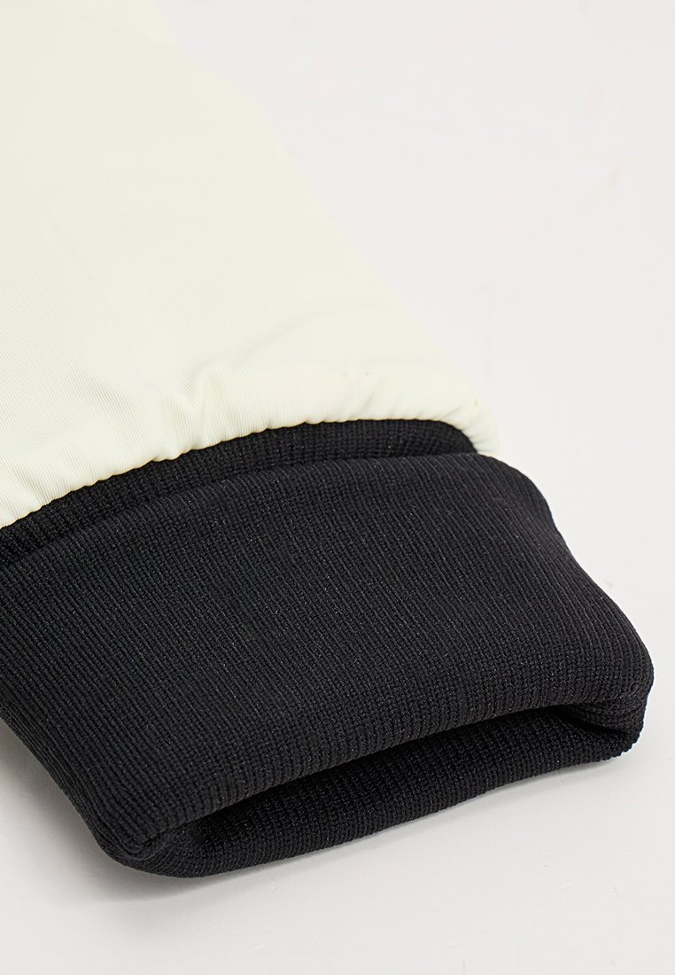 Poignet en tricot noir avec un matériau élastique blanc au-dessus. Texture lisse avec des couleurs contrastantes. Le poignet présente un design côtelé, offrant de l'élasticité.