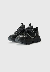 Sorte sneakers med en chunky design, lædermateriale, sølvnitter og en kædeaccent. Tekstureret grebsål. Snørebåndslukning med trækflap.