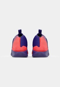 Purple and red athletic shoes, with a textured upper, rounded heel, and pull tab at the back for easy wear. Slim profile design.